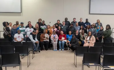 this is a large smiling group photo of community and local partnerships, Brooklyn Park employees, the Mayor, NHCC alumni and local leaders together in Helling Hall on the stage posing for a photo at a Civic Engagement Series event we hosted in fall 2025. 