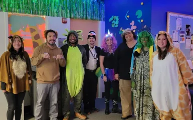 this is a photo of NHCC's Advising staff, smiling for the camera, posing in their animal Halloween costumes for a group photo. 