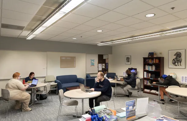 students on laptops in the writing center