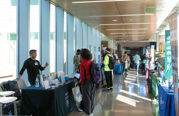 people talking by tables in a hallway