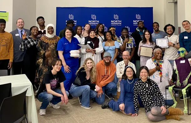 This is a group photo of various students and staff who attended the Student Life Awards Banquet. The group piled together for a photo in front of the NHCC logo backdrop. 