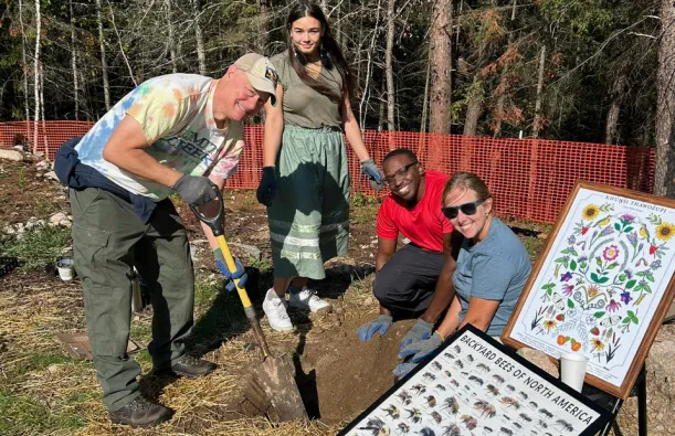 students digging in dirt outside with an instructor 
