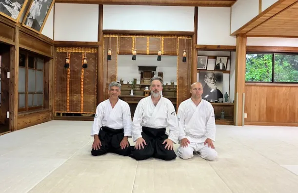 this is a photo of NHCC faculty Mark Larson and NHCC alumni Kyle Knutson sitting on the floor at the Iwama Dojo, Birthplace of Aikido in Japan. 