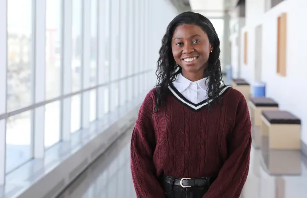 this is a photo of NHCC biology student, Danista Kannah, smiling in the hallway of the BHCC building on the 2nd floor. 