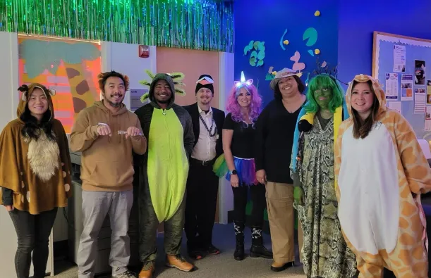 this is a photo of NHCC's Advising staff, smiling for the camera, posing in their animal Halloween costumes for a group photo. 