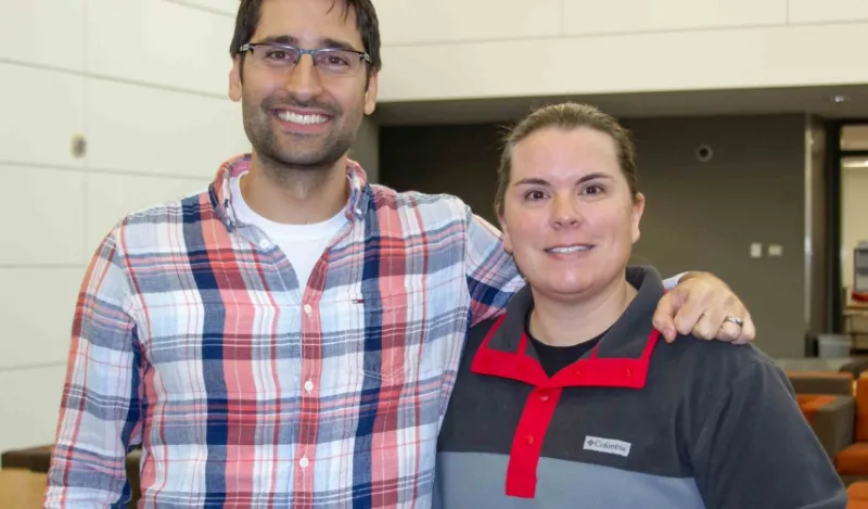 male and female faculty members smiling inside