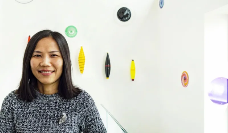 computer science student standing inside art decorated hallway smiling at the camera