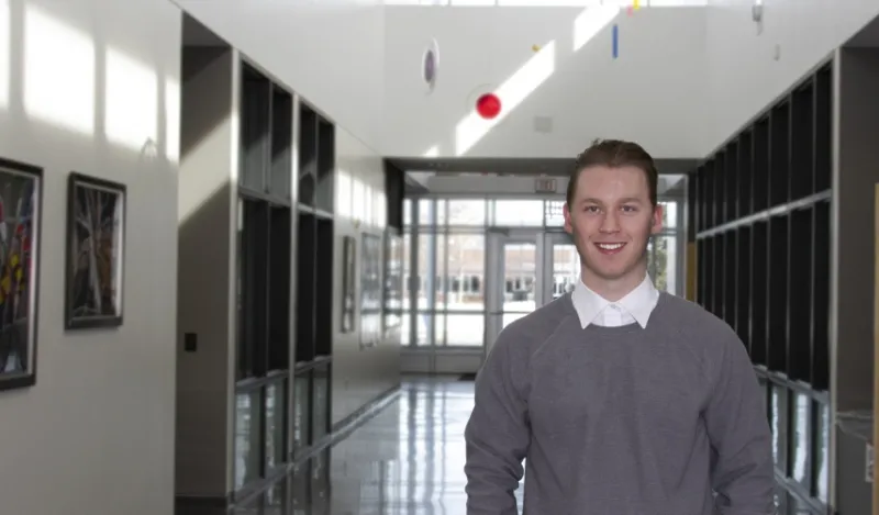 student Nathan standing in a hallway