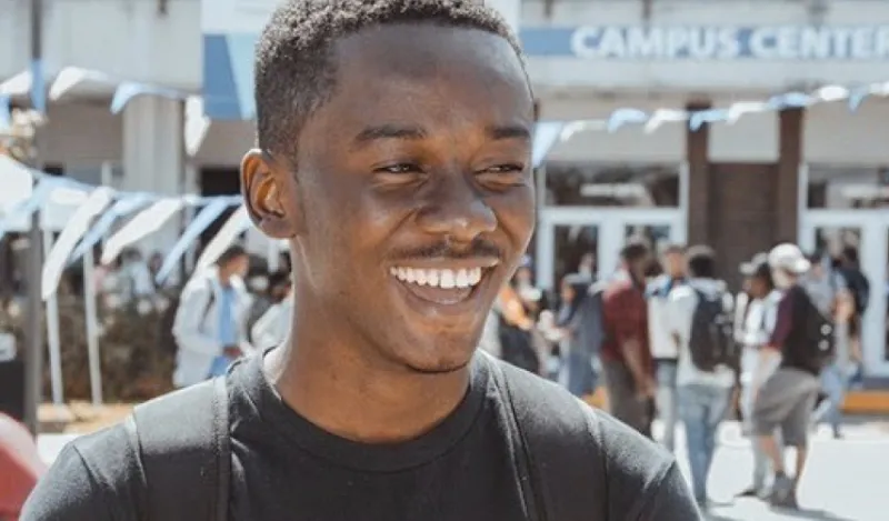 TRIO alumni Afeez Sodeind standing outside a busy campus center