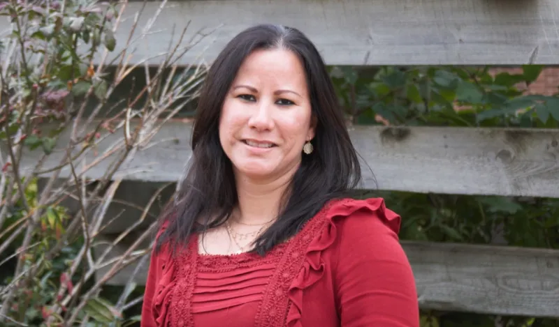 faculty member and veteran Janet Lorenzo standing outside smiling at the camera