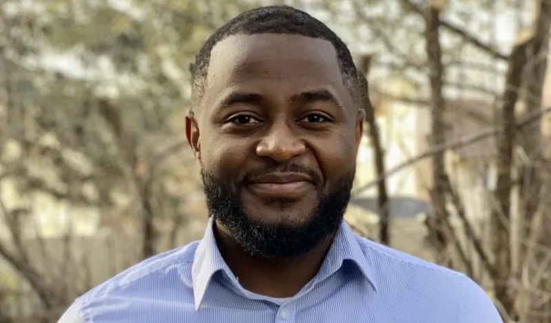 STEM alumni Alain Njipwo outside smiling at camera