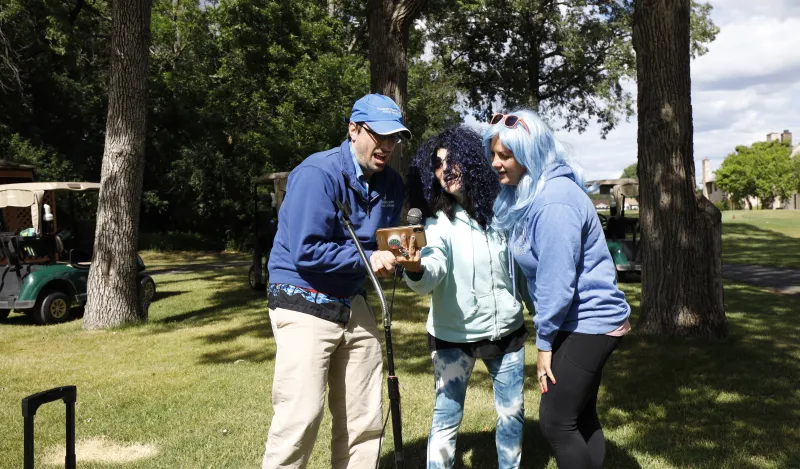 NHCC staff singing karaoke at golf event 