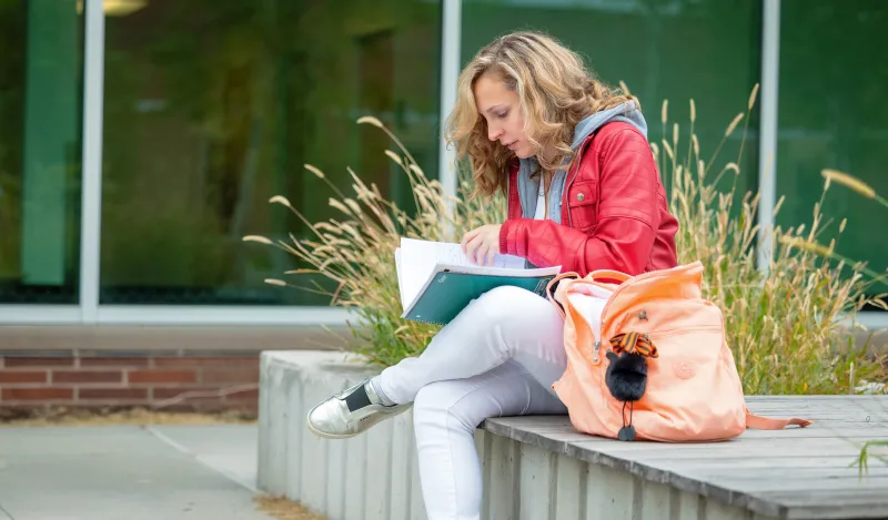 female, adult student studying outside