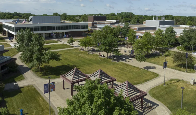 arial view of campus courtyard with trees buildings and a few students 