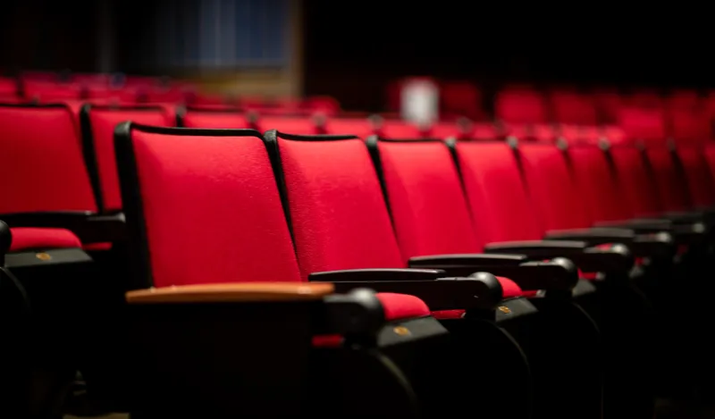 a row of red seats in a theater 