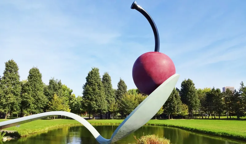 sculpture of cherry on a spoon over water