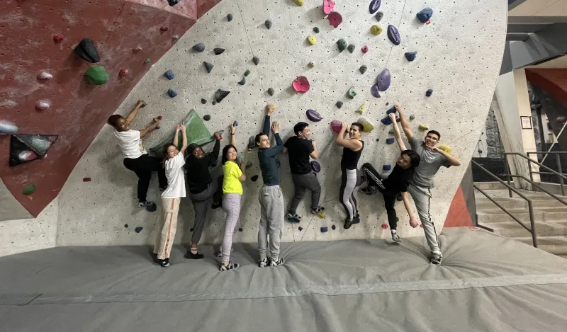 group photo in front of rock climbing wall