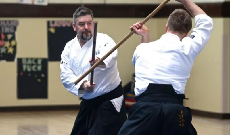 two men using wooden swords