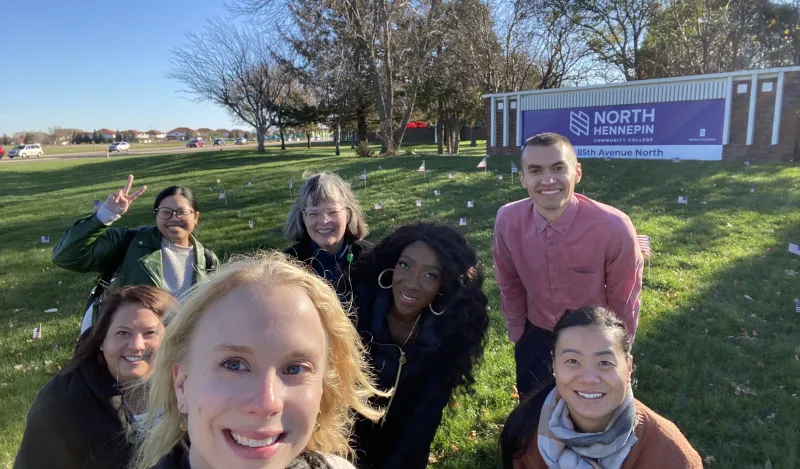 A photo of NHCC's Beyond The Yellow Ribbon Committee Members with flags outside on Veterans Day