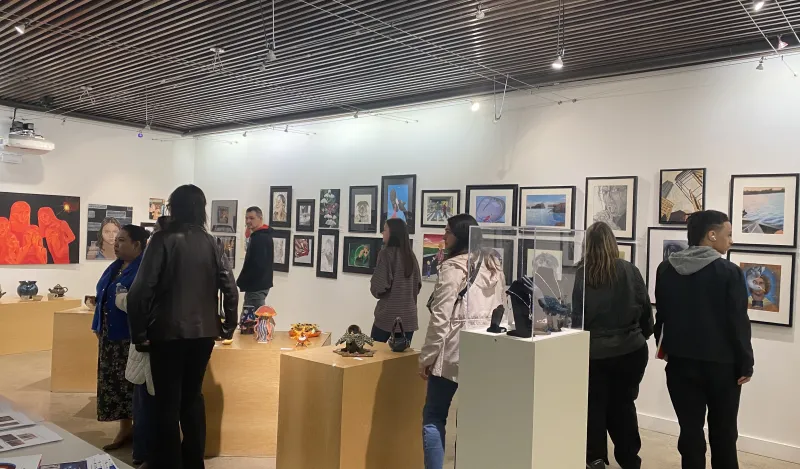 people gather in the gallery to view art 