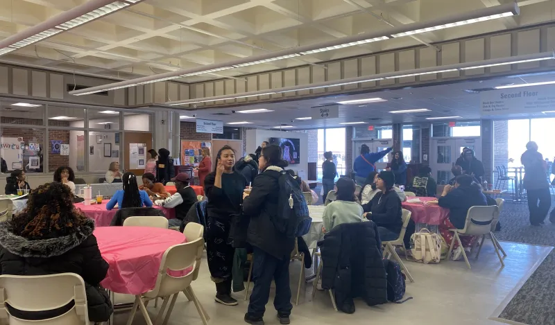 a photo of students gathering, sitting at tables and conversing at our Student Appreciation Day event in the Campus Center. 