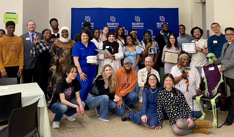 This is a group photo of various students and staff who attended the Student Life Awards Banquet. The group piled together for a photo in front of the NHCC logo backdrop. 