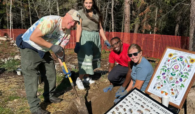 students digging in dirt outside with an instructor 