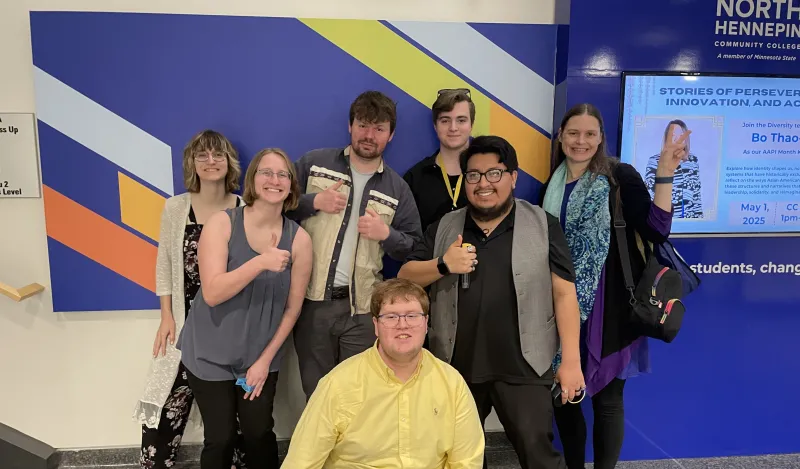 group standing in front of blue wall with strips of color