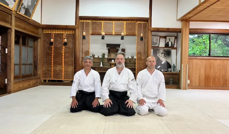 this is a photo of NHCC faculty Mark Larson and NHCC alumni Kyle Knutson sitting on the floor at the Iwama Dojo, Birthplace of Aikido in Japan. 