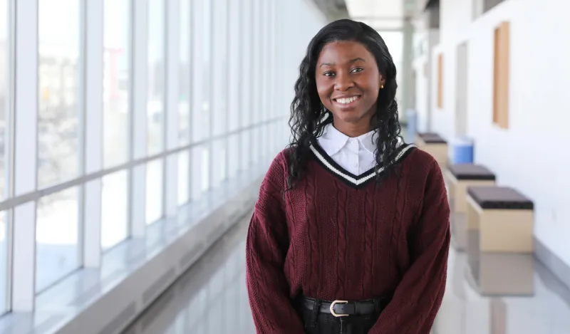 this is a photo of NHCC biology student, Danista Kannah, smiling in the hallway of the BHCC building on the 2nd floor. 