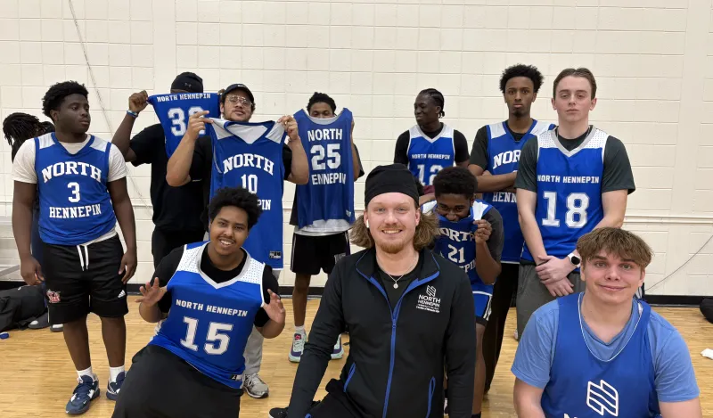 group of students wearing blue jerseys posing for a photo