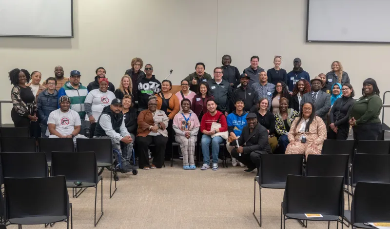 this is a large smiling group photo of community and local partnerships, Brooklyn Park employees, the Mayor, NHCC alumni and local leaders together in Helling Hall on the stage posing for a photo at a Civic Engagement Series event we hosted in fall 2025. 