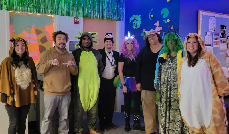 this is a photo of NHCC's Advising staff, smiling for the camera, posing in their animal Halloween costumes for a group photo. 