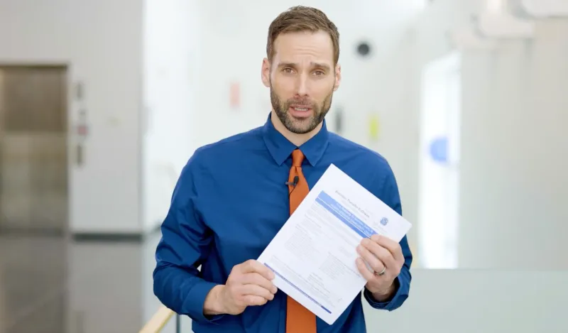 male instructor holding a piece of paper 