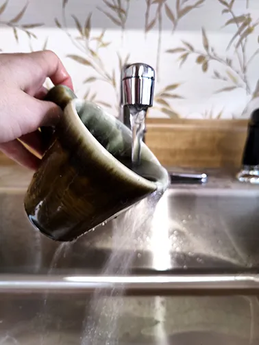 a photo of a mug being washed