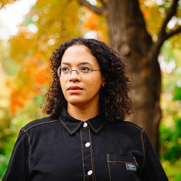 LM (Lisa Marie) Brimmer standing outside in front of a tree in fall