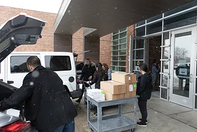 people loading in boxes near large doors 