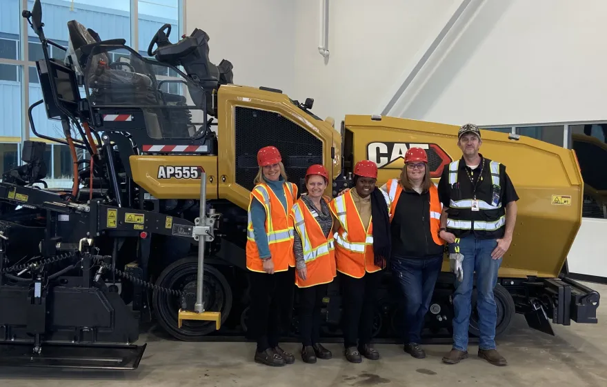 Photo of an NHCC student and mentors with an asphalt paver machine