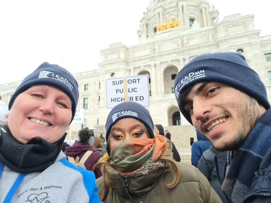 students wearing winter clothing with the state capital in the background