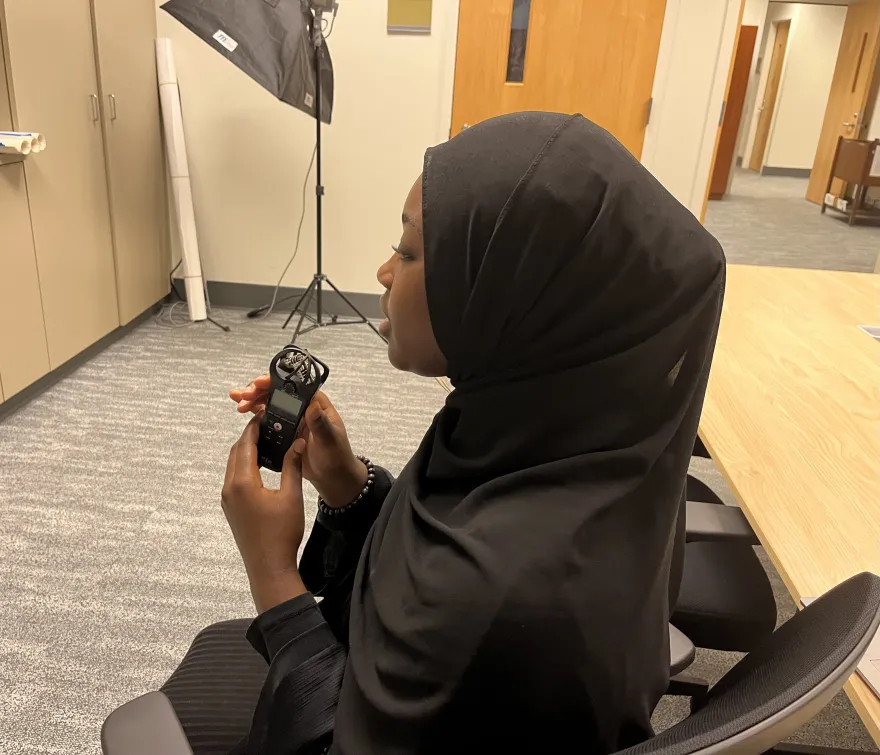 profile view of female wearing a hijab being interviewed