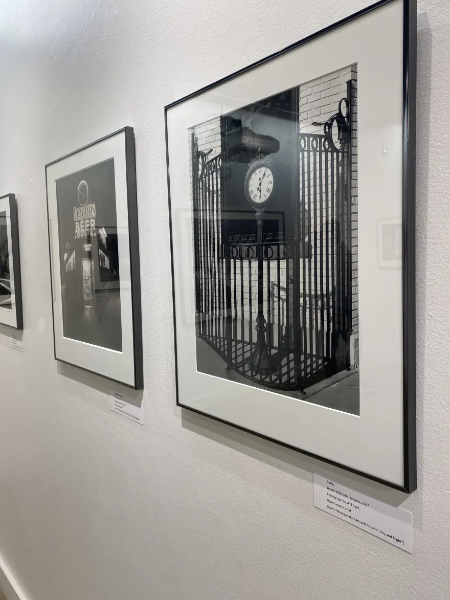 a black and white photo of a tall clock on the street 