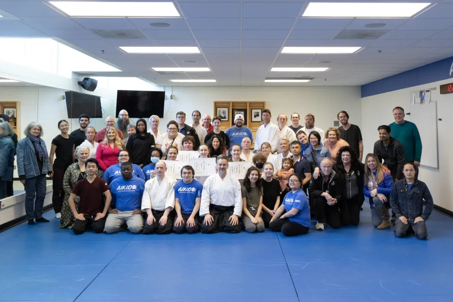 large group of people kneeling and standing in a studio