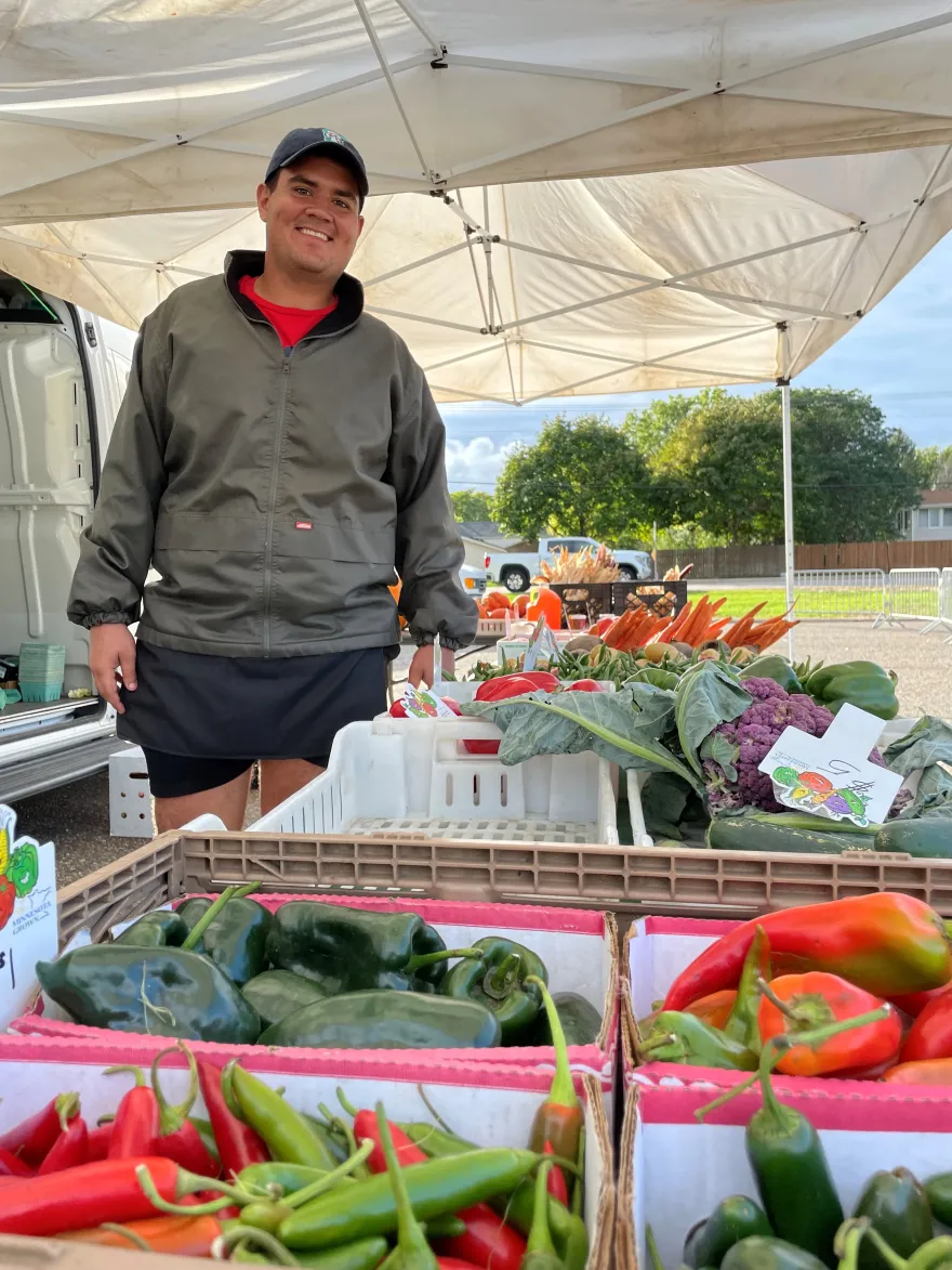 vegetables and a smile vendor at the farmers market