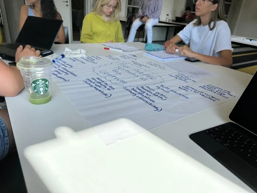 a photo of NHCC student, Donald Agik and his group working on a project at a table in the Netherlands