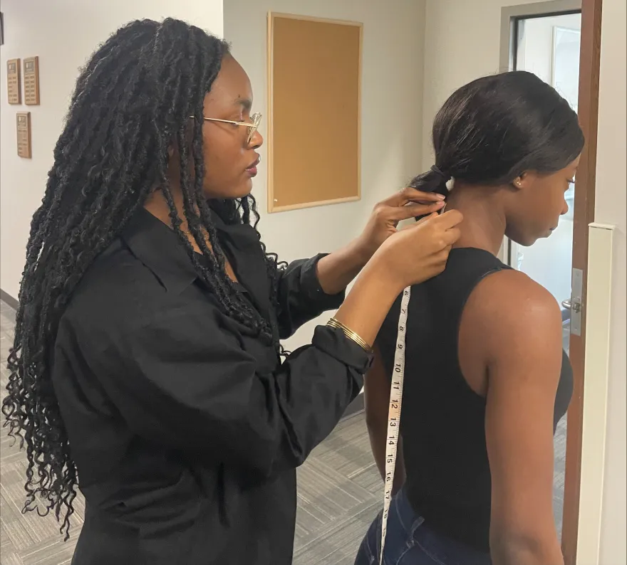 NHCC student measuring model for fashion show 