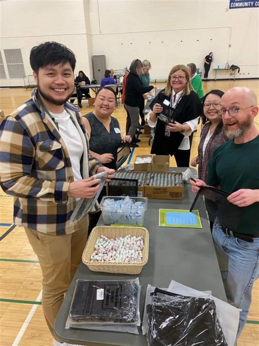 NHCC Employees smile at Guided Learning Pathways Day while volunteering to make Hygiene Kits