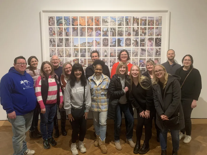 a photo of NHCC TRIO staff with NHCC MKTG staff smiling next to an exhibit at the Minneapolis Institute of Arts 