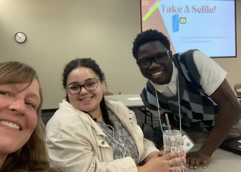 a photo of two PTK students and Deane Newborn in St. Cloud for a PTK conference, smiling at the camera. 