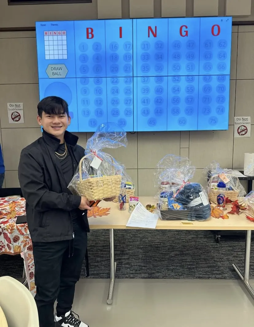a photo of a student smiling with their prize from playing Bingo in the Campus Center 