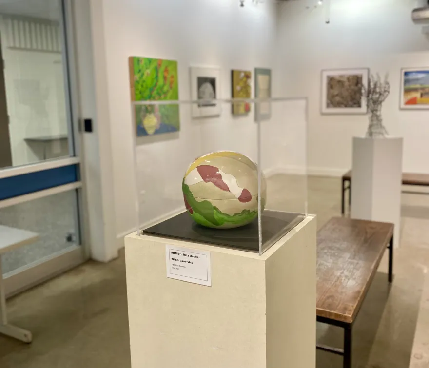a photo of a colorful ceramic sphere created by an artist in 1976 on display in the gallery. 